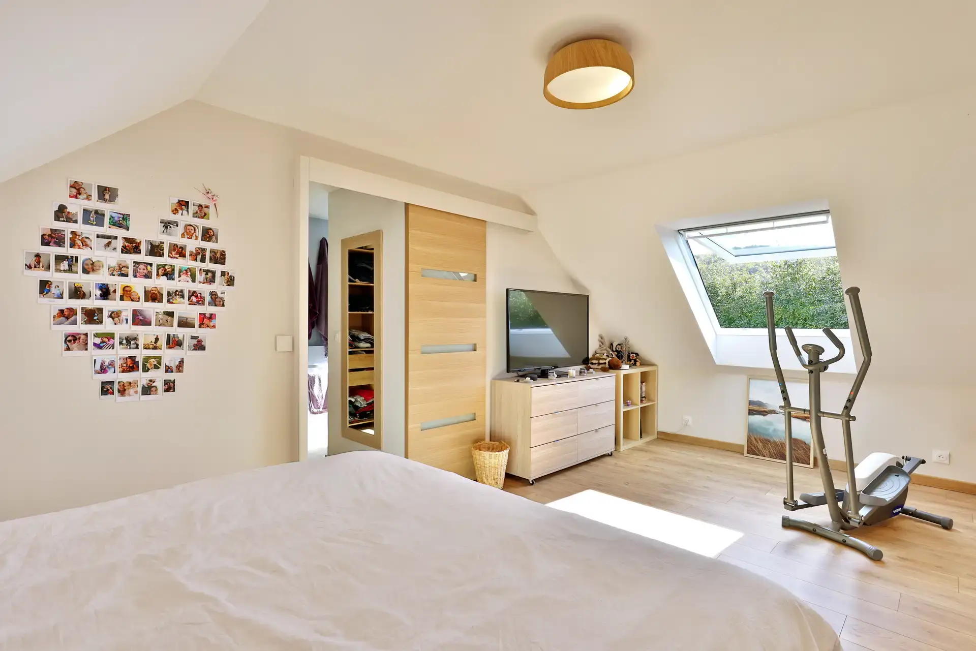 Chambre aménagée sous combles, avec fenêtre de toit et dressing